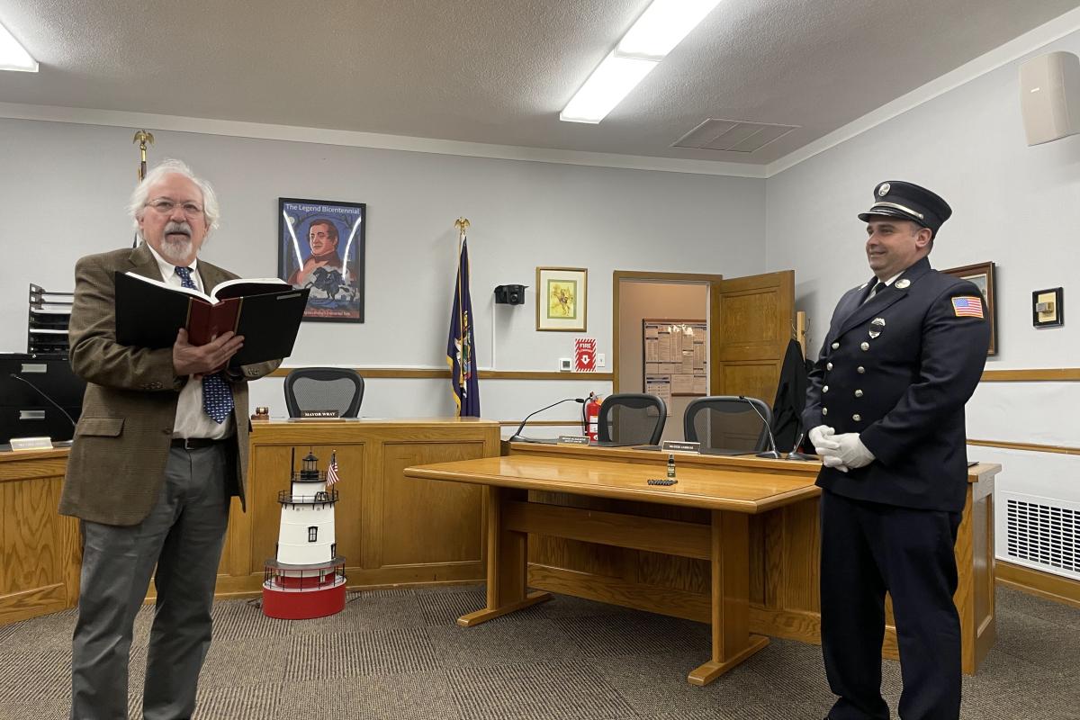 Officiant Reading From a Book Swearing in an Officer
