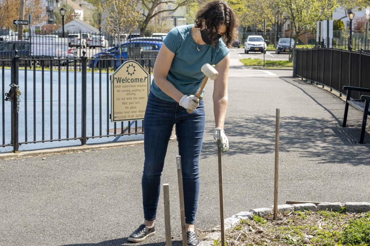 Woman Hammering Post Into Ground