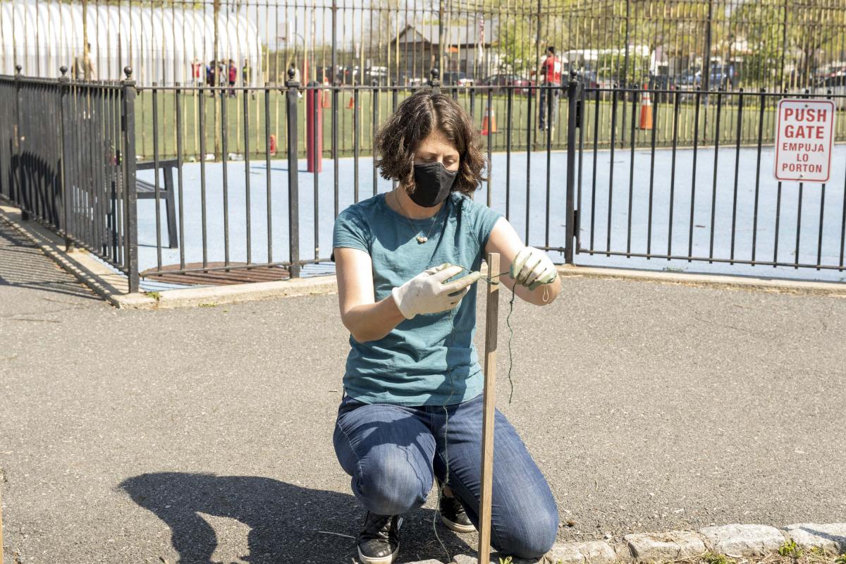 Woman Tying String Around Post